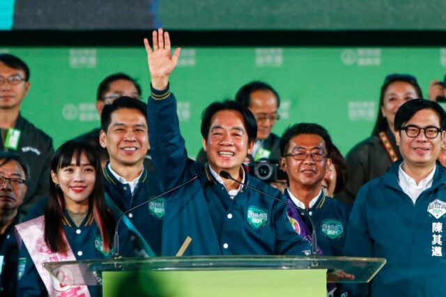 William Lai, o candidato presidencial do DPP.  Hs está no palco e vestindo o verde de sua festa.  Ele está reconhecendo a multidão.