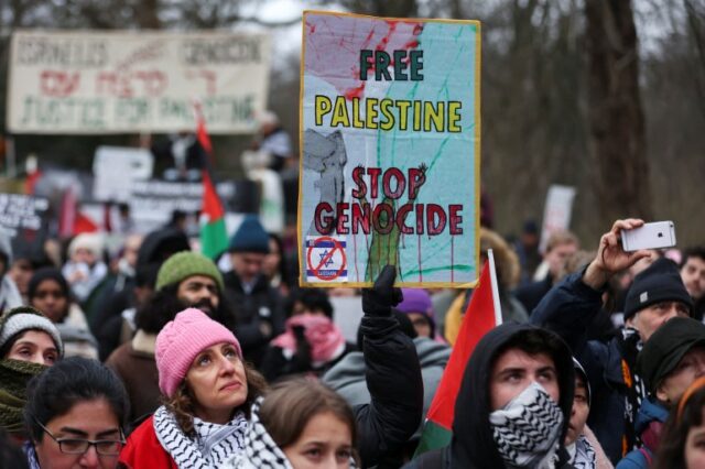 Manifestantes pró-Palestina seguram bandeiras palestinas enquanto protestam perto do Tribunal Internacional de Justiça (CIJ)