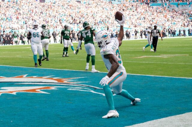 O running back do Miami Dolphins, Raheem Mostert (31), joga a bola no campo enquanto comemora um touchdown durante um jogo de futebol americano da NFL contra o New York Jets, domingo, 17 de dezembro de 2023, em Miami Gardens, Flórida. Murray)