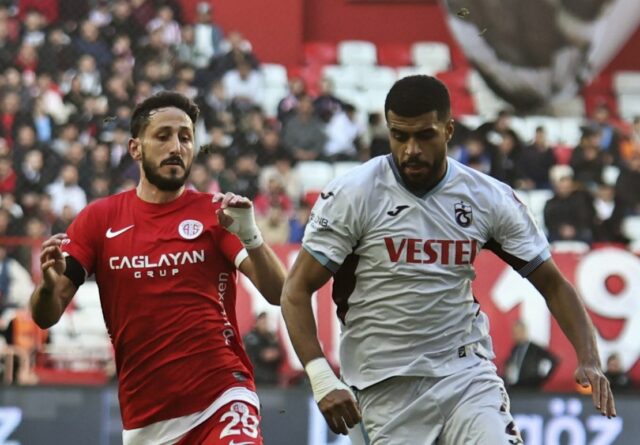 Sagiv Jehezkel, do Antalyaspor, à esquerda, disputa a bola com Rayyan Baniya, do Trabzonspor, durante uma partida de futebol da Super Lig turca entre Antalyaspor e Trabzonspor em Antalya, sul da Turquia, domingo, 14 de janeiro de 2024. As autoridades turcas detiveram o clube de futebol da primeira divisão turca, Antalyaspor. O jogador israelense Sagiv Jehezkel para interrogatório após demonstrar solidariedade às pessoas mantidas reféns pela organização militante Hamas durante um jogo da liga.  (Cafer Eser/IHA via AP)