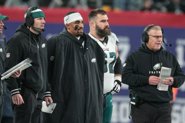 O quarterback do Philadelphia Eagles, Jalen Hurts (centro-esquerda) e o central Jason Kelce (62), assistem durante o segundo tempo contra o New York Giants no MetLife Stadium.