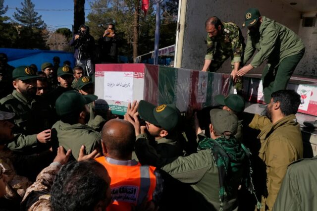 Membros da Guarda Revolucionária carregam o caixão coberto com a bandeira iraniana de Nazanin Fatemeh Azizi
