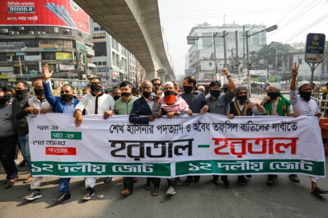 Ativistas da aliança de oposição de Bangladesh marcham segurando uma faixa com as palavras 