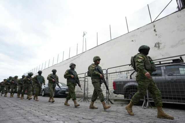 Policiais e soldados se preparam para entrar na prisão de El Inca para reprimir um motim em Quito, Equador