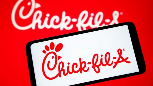O logotipo Chick-fil-A em um telefone celular com fundo vermelho