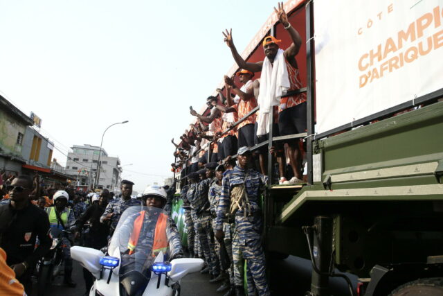 Jogadores da Costa do Marfim comemoram seu sucesso nas ruas de Abidjan com torcedores