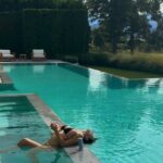 Kylie Jenner relaxando na piscina de biquíni preto.
