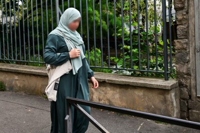 uma mulher vestindo uma abaya andando pelas ruas de Paris