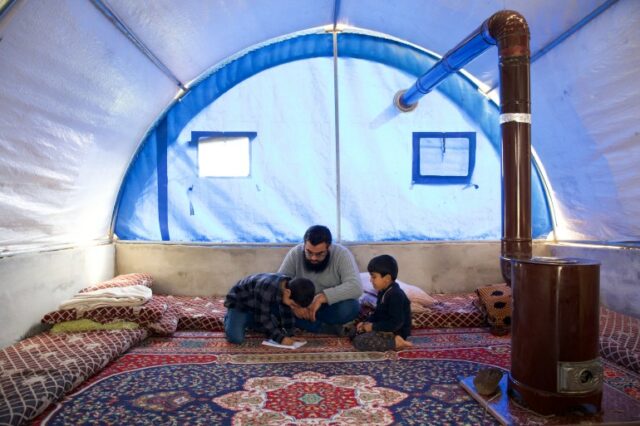 Ibrahim com seus filhos em uma tenda azul