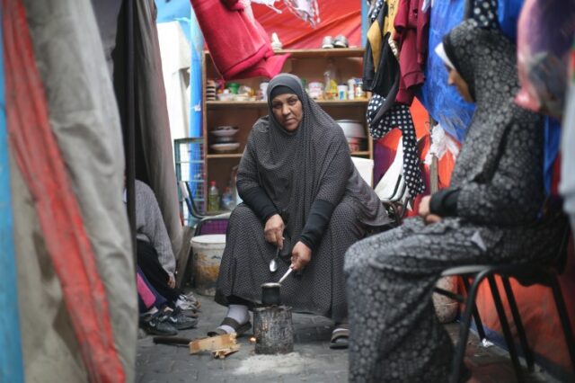 Mona Abdelraheem levanta os olhos do pequeno fogo que acendeu em uma lata para preparar um café