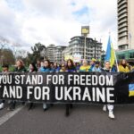 Pessoas seguram uma faixa enquanto protestam no aniversário de dois anos da invasão da Ucrânia pela Rússia, em Londres, Grã-Bretanha, 24 de fevereiro