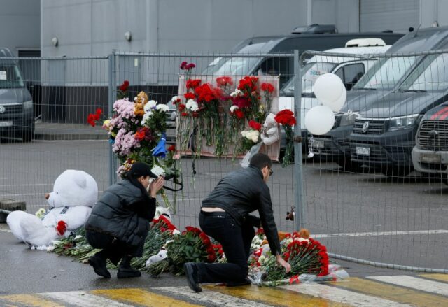 Pessoas depositam flores em um memorial improvisado às vítimas de um ataque a tiros na sala de concertos Crocus City Hall, na região de Moscou, Rússia, em 23 de março.