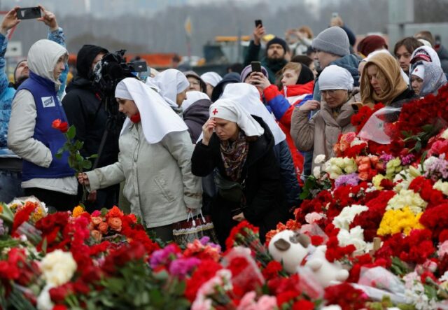 Pessoas depositam flores em um memorial improvisado às vítimas de um ataque a tiros organizado em frente à sala de concertos Crocus City Hall, na região de Moscou, Rússia, 24 de março de 2024. REUTERS/Maxim Shemetov