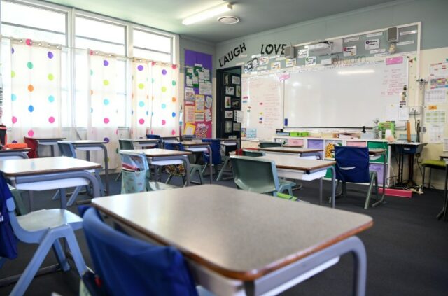 uma sala de aula vazia com cartazes que dizem 'amor' e 'rir acima do quadro branco