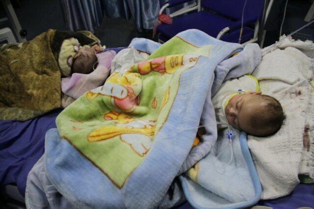 BEIT LAHIA, GAZA - 2 DE MARÇO: Bebês, hospitalizados devido à desnutrição e desidratação, estão deitados em uma cama de hospital no Hospital Kamal Adwan em Beit Lahia, Gaza, em 2 de março