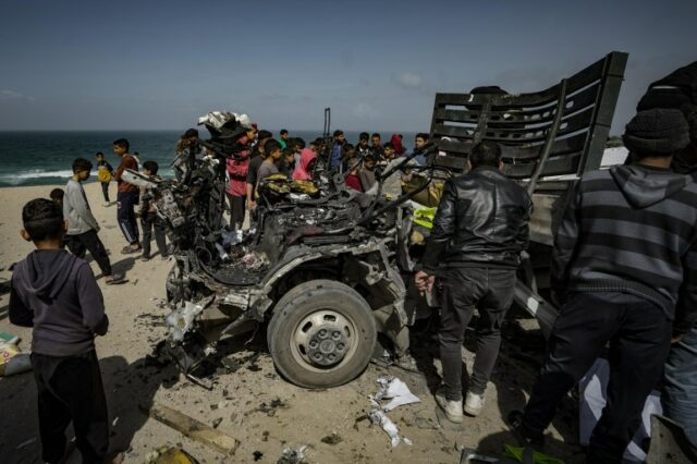 Palestinos inspecionam o veículo de ajuda humanitária fortemente danificado, que foi alvo de ataques aéreos israelenses que resultaram na morte de nove e dezenas de feridos, em Deir al-Balah, Gaza, em 3 de março.