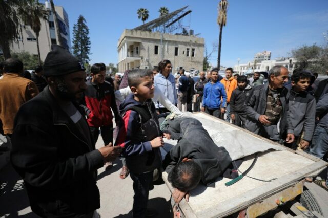 Palestinos feridos, incluindo crianças, são levados ao Hospital Batista al-Ahli depois que Israel atingiu palestinos que esperavam por ajuda humanitária na junção do Kuwait, na Cidade de Gaza, Gaza, em 23 de março.