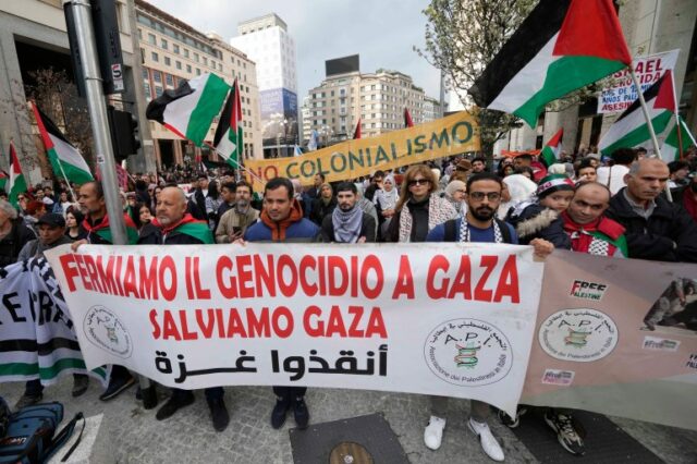 Manifestantes seguram uma faixa com os dizeres “Parem o genocídio em Gaza, salvem Gaza” durante um comício em Milão