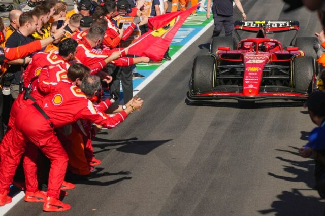 O piloto da Ferrari, Carlos Sainz, da Espanha, dirige seu carro para o pit lane enquanto seus companheiros comemoram após vencer o Grande Prêmio da Austrália de Fórmula 1 em Albert Park, em Melbourne, Austrália, domingo, 24 de março de 2024. (AP Photo / Scott Barbour)