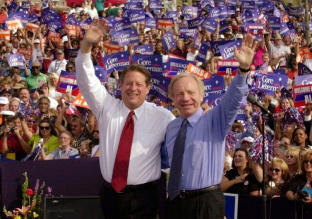 Diante de uma multidão de apoiadores, Al Gore e Joe Lieberman acenam.