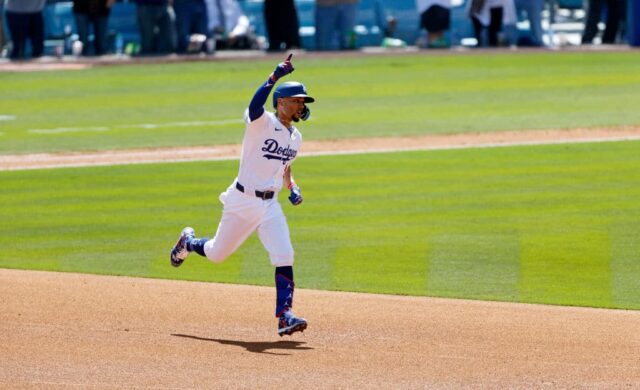 Mookie Betts nº 50 do Los Angeles Dodgers comemora enquanto corre pelas bases depois de acertar um home run de uma corrida contra o arremessador Miles Mikolas nº 39 do St. Louis Cardinals durante a terceira entrada no dia de abertura no Dodger Stadium em 28 de março de 2024 em Los Angeles, Califórnia.