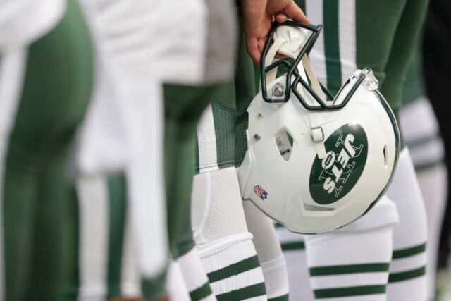 Um capacete do New York Jets é colocado atrás das costas de um jogador durante o hino nacional antes da ação da NFL contra o Kansas City Chiefs no Arrowhead Stadium antes do jogo em 25 de setembro de 2016 em Kansas City, Missouri.