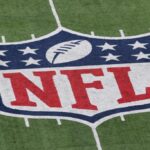 Um detalhe do logotipo oficial da National Football League NFL é visto pintado no gramado quando o New York Giants recebe o Atlanta Falcons durante o jogo NFC Wild Card Playoff no MetLife Stadium em 8 de janeiro de 2012 em East Rutherford, Nova Jersey.