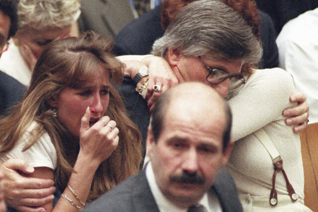 ARQUIVO - Fred Goldman, pai de Ron Goldman, abraça sua esposa Patti, enquanto sua filha, Kim, à esquerda, reage aos veredictos de inocência no julgamento de duplo homicídio de OJ Simpson, 3 de outubro de 1995,