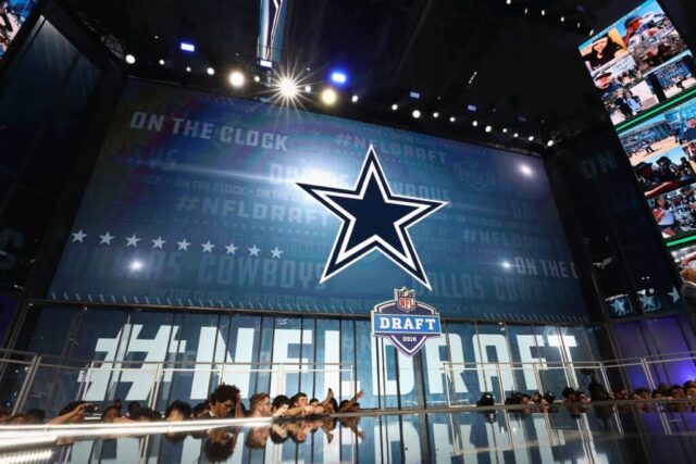 O logotipo do Dallas Cowboys é visto em uma placa de vídeo durante a primeira rodada do Draft da NFL 2018 no AT&T Stadium em 26 de abril de 2018 em Arlington, Texas.