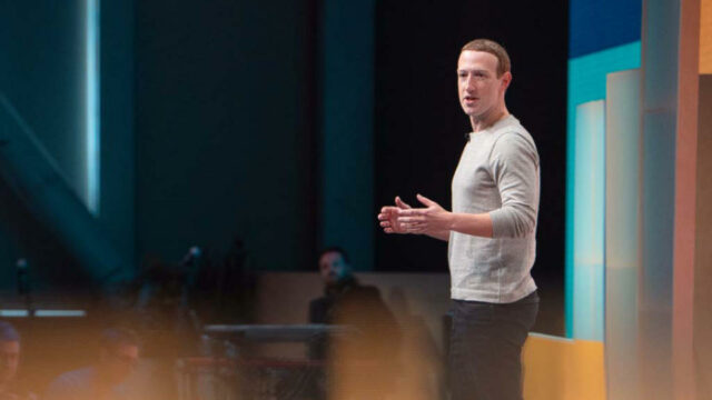 Mark Zuckerberg no palco durante uma apresentação da empresa.  Vista de perfil do lado esquerdo.