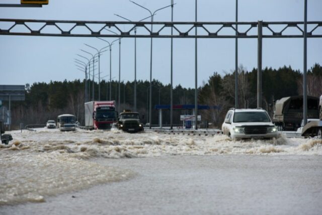 Carros circulam por um trecho inundado de uma estrada na cidade de Petropavl, no norte do Cazaquistão, perto da fronteira com a Rússia, em 14 de abril de 2024. (Foto de Evgeniy Lukyanov / AFP)