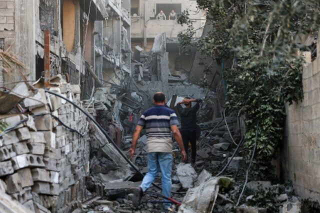Palestinos verificam os escombros de um prédio após bombardeio israelense no bairro de Al-Daraj