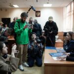Alexandra Bayeva (L) e Katerina Tertukhina, advogadas de Oleg Orlov, falam à imprensa.  Eles estão sentados a uma mesa.  A mídia está na frente deles.