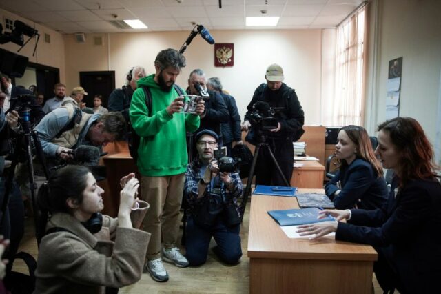 Alexandra Bayeva (L) e Katerina Tertukhina, advogadas de Oleg Orlov, falam à imprensa.  Eles estão sentados a uma mesa.  A mídia está na frente deles.