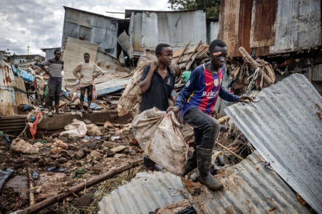 Meninos carregam alguns de seus pertences após enchentes em Nairóbi
