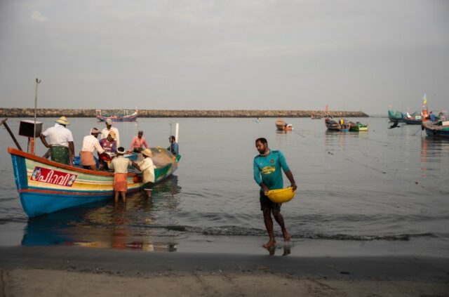Um pescador caminha até a costa carregando uma cesta de peixes em um porto de pesca na costa do Mar da Arábia em Kochi, estado de Kerala, Índia, segunda-feira, 20 de setembro de 2021. (AP Photo/RS Iyer)