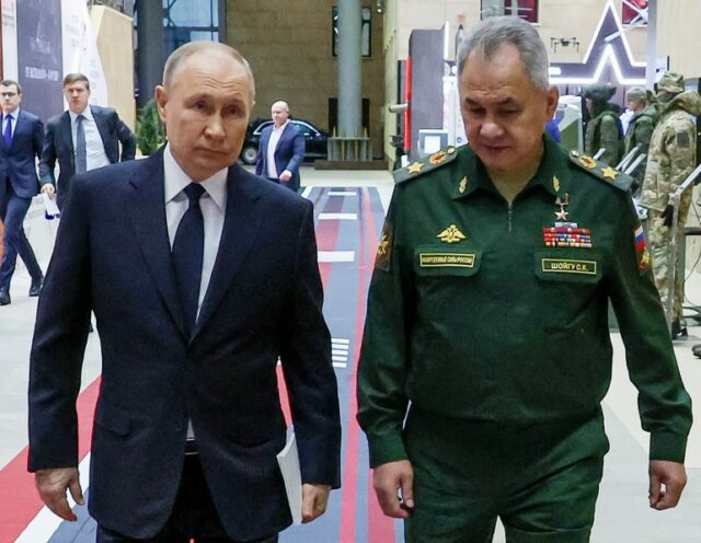 O presidente russo, Vladimir Putin (à esquerda), e o ministro da Defesa russo, Sergei Shoigu, caminhando juntos