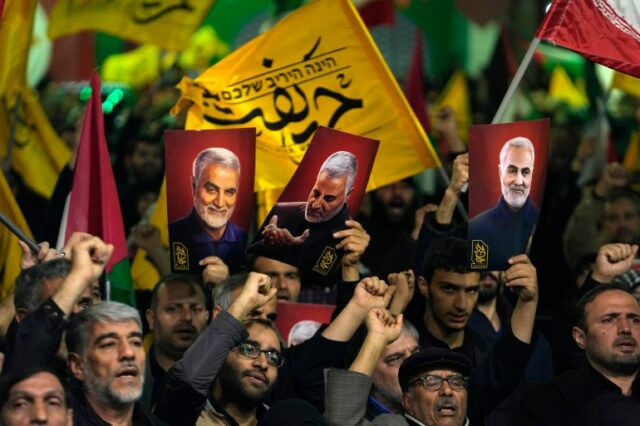 Manifestantes em Teerã.  Eles seguram cartazes do general da Guarda Revolucionária Iraniana Qassem Soleimani, que foi morto em um ataque de drone dos EUA em 2020. 