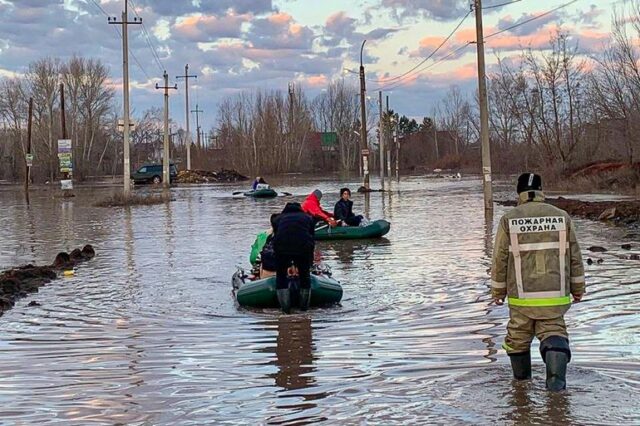 Nesta foto tirada e divulgada pela Administração do canal de telegramas da cidade de Orenburg na sexta-feira, 5 de abril de 2024, pessoas usam barcos durante a evacuação após o rompimento de parte de uma barragem, causando inundações, em Orsk, na Rússia. 