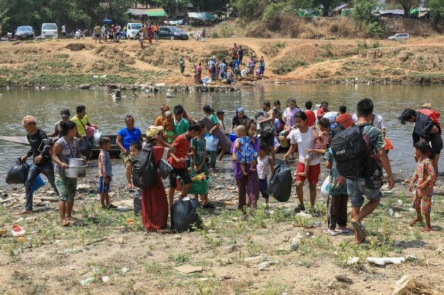Pessoas atravessam o rio Moei enquanto fogem do município de Myawaddy
