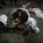 Um jovem palestino lamenta a morte de um parente morto no bombardeio israelense na Faixa de Gaza, no necrotério do Hospital do Kuwait no campo de refugiados de Rafah, sul da Faixa de Gaza, na manhã de sábado, 20 de abril de 2024.