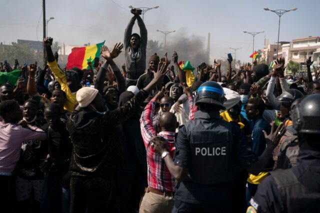 Manifestantes gritam slogans na frente da tropa de choque durante um protesto contra a prisão do líder da oposição e ex-candidato presidencial Ousmane Sonko, Senegal, segunda-feira, 8 de março de 2021 (Leo Correa/AP Photo)