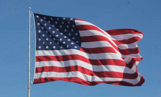 Bandeira americana balançando em um mastro de bandeira em escala