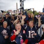 Os fãs do New England Patriots reagem à seleção de seus times na segunda rodada do Draft da NFL de 2023 na Union Station em 28 de abril de 2023 em Kansas City, Missouri.