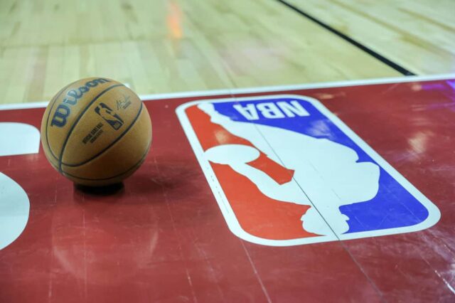Uma bola de basquete é colocada na quadra ao lado de um logotipo da NBA durante um intervalo no primeiro tempo de um jogo da NBA Summer League de 2023 entre o Portland Trail Blazers e o Houston Rockets no Thomas & Mack Center em 7 de julho de 2023 em Las Vegas, Nevada.