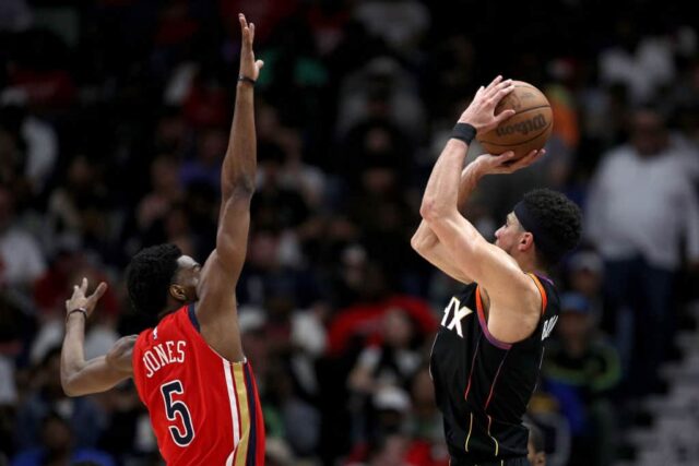 Devin Booker nº 1 do Phoenix Suns arremessa uma cesta de três pontos sobre Herbert Jones nº 5 do New Orleans Pelicans durante o segundo quarto de um jogo da NBA no Smoothie King Center em 01 de abril de 2024 em Nova Orleans, Louisiana. 