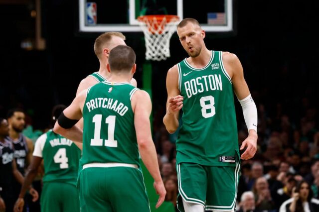 Kristaps Porzing é o 8º dos pontos do Boston Celtics contra Payton Pritchard, o 11º, depois que Pritchard acertou uma cesta de três pontos durante o segundo tempo contra o Sacramento Kings no TD Garden em 5 de abril de 2024 em Boston, Massachusetts.