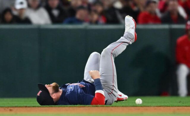 Trevor Story nº 10 do Boston Red Sox reage após se machucar após uma bola rebatida por Mike Trout nº 27 do Los Angeles Angels na quarta entrada durante o dia de abertura de um jogo da Liga Principal de Beisebol no Angel Stadium de Anaheim em 5 de abril, 2024 em Anaheim, Califórnia. 