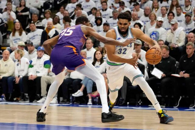 Karl-Anthony Towns #32 do Minnesota Timberwolves dribla a bola contra Kevin Durant #35 do Phoenix Suns durante o primeiro quarto do primeiro jogo dos Playoffs da Primeira Rodada da Conferência Oeste no Target Center em 20 de abril de 2024 em Minneapolis, Minnesota.
