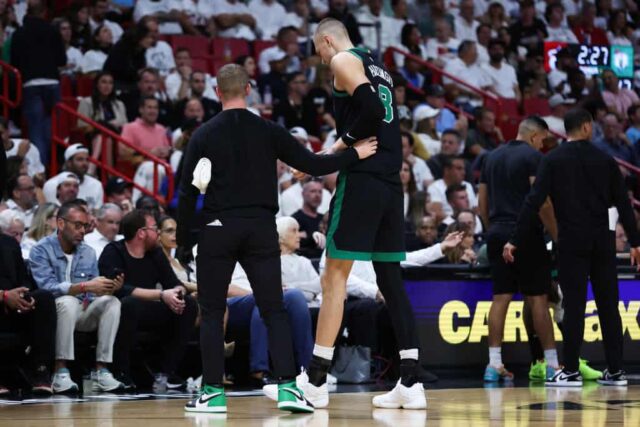 Kristaps Porzingis # 8 do Boston Celtics deixa o jogo contra o Miami Heat durante o segundo quarto depois de sofrer uma aparente lesão no quarto jogo dos Playoffs da Primeira Rodada da Conferência Leste no Kaseya Center em 29 de abril de 2024 em Miami, Flórida.
